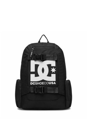 Sort DC Shoes rygsæk med stort hvidt logo foran, to sidelommer, en top lynlåslomme og to justerbare frontstropper med spænder.