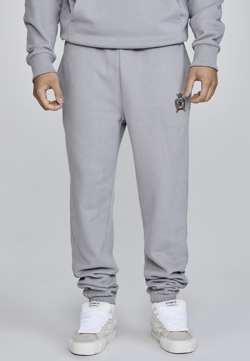 Graue Sweatpants aus weichem Stoff, mit einem elastischen Bund und Bündchen. Mit einem gestickten Logo-Akzent am linken Oberschenkel.