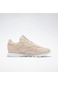 Baskets en cuir beige avec semelle et lacets blancs, vue de profil sur fond blanc uni.