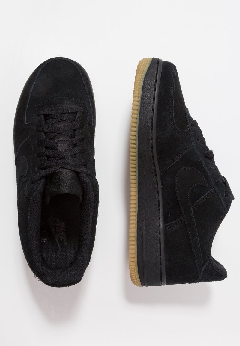 Sneakers in suede nero con suola in gomma, caratterizzati da un motivo testurizzato e lacci tono su tono. Punta rotonda, design minimalista, senza branding visibile.