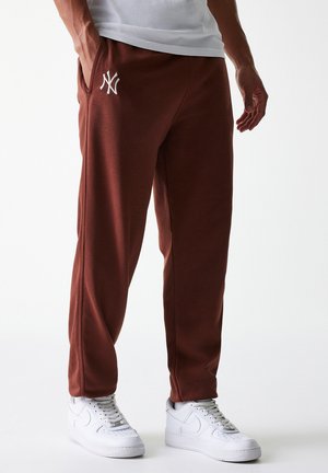Bordeauxfarvede sweatpants med hvidt broderet logo på venstre lår, sidelommer, tapered design og lavet af blødt stof. Bæres med hvide sneakers.