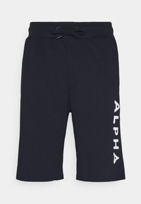 Sorte knælange shorts med elastisk talje og snøre, med lodret hvid tekst "ALPHA" på højre ben.
