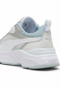 Baskets blanches et bleu clair avec une tige texturée, un design élégant, un col rembourré et une semelle extérieure en caoutchouc proéminente dotée de détails rainurés.