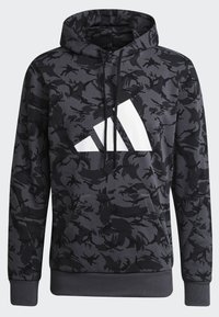 Sweat à capuche à motif camouflage gris foncé et noir avec poche avant, cordons de serrage et grand logo géométrique blanc sur la poitrine.