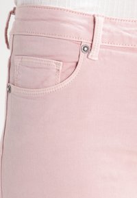 Roze spijkerbroek met een middelhoge taille, een klein voorvakje en zilveren hardware-accenten met een gladde textuur.