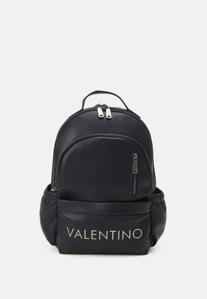 Sac à dos Valentino noir avec poches zippées à l'avant et sur les côtés, double zip sur le dessus et une poignée sur fond uni.