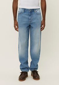 Lys blå denimjeans med rett benpassform, frontlommer og en falmet vask. Jeansen har en jevn tekstur og detaljer i sølvfarge.