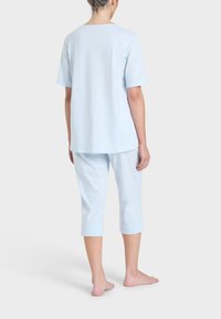 Set di abbigliamento comodo azzurro chiaro composto da una maglietta a maniche corte con scollo rotondo e pantaloni corti con orlo a risvolto. Tessuto misto cotone.