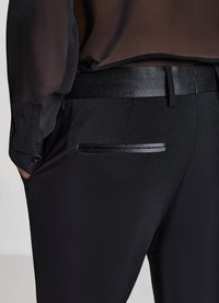 Schwarze, maßgeschneiderte Hosen mit glatter Textur, ausgestattet mit einem dünnen Satinbund und einem eleganten Akzent an der Gesäßtasche.