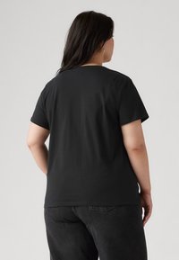 Black cotton t-shirt with short sleeves, round neckline, and a relaxed fit. Simplistic design, no visible patterns or hardware details.