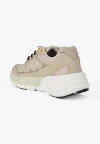 Scarpa da corsa beige con tomaia in suede strutturato, chiusura con lacci neri e una suola intermedia bianca spessa con suola esterna nera.