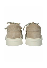 Chaussures en daim beige à profil bas, avec un bout rond, des lacets à l'avant et une surface texturée. Logo "BLACKSTONE" au niveau du talon.