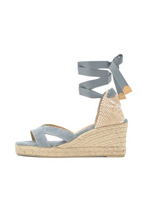 Sandalia de cuña espadrille con tiras de tela azul claro que cruzan el frente y envuelven el tobillo, tacón cerrado tejido y suela plataforma con textura de cuerda.