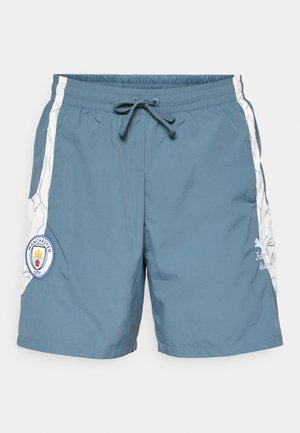 Meeste ujumispüksid teal värvuses, elastse vöökoha ja nööriga, valgete külgeheitega ning Manchester City logo pääsmega.