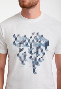 Bílý tričko s krátkým rukávem se geometrickým modrým abstraktním vzorem s vrstevnými designy kostek, texturovanou tkaninou a jemnými detaily šití.