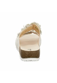 White sandal with a textured cork sole and floral accents on the upper. Open back design, flat heel, and smooth interior.