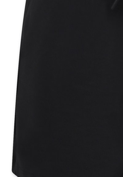 Gonna nera in cotone con una texture liscia, caratterizzata da un design semplice e una cintura elastica senza accenti o motivi aggiuntivi.