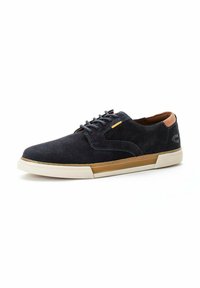 Marineblauwe suède sneaker met bruine leren accenten, witte rubberen zool, ronde veters en een gestructureerde stof. Kenmerkt een subtiele logo op de hak.