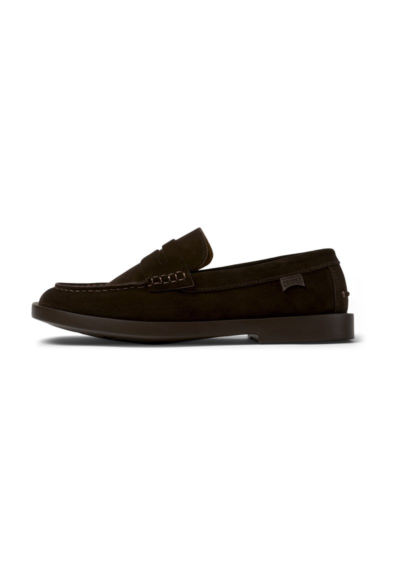 Donkerbruin suède instapper met een gestikte moccasinpunt en een decoratieve band. Vlakke rubberen zool met een subtiele merketiket aan de zijkant.