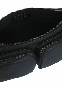 Interno di una borsa in pelle nera, con due scomparti zip, superficie testurizzata e fodera interna liscia. Design compatto e funzionale.