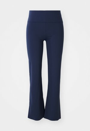 Pantalone tamnoplave boje s ravnim fitom od rastezljivog materijala s širokim pojasom. Glatka tekstura i bez vidljivih uzoraka ili metalnih detalja.