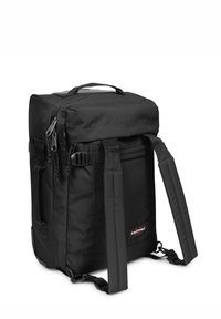 Zaino nero con forma rettangolare, realizzato in nylon resistente. Presenta spallacci imbottiti, maniglia superiore, cerniere e il logo Eastpak.