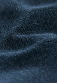 Tela de mezclilla oscura con una superficie texturizada, que presenta patrones de tejido visibles y un acabado suave, mostrando tonos azules intensos.