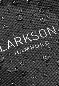 Čierna tkanina s kvapkami vody, s nápisom „LARKSON HAMBURG“ jasne zobrazeným v bielej farbe. Viditeľný textúrovaný materiál.