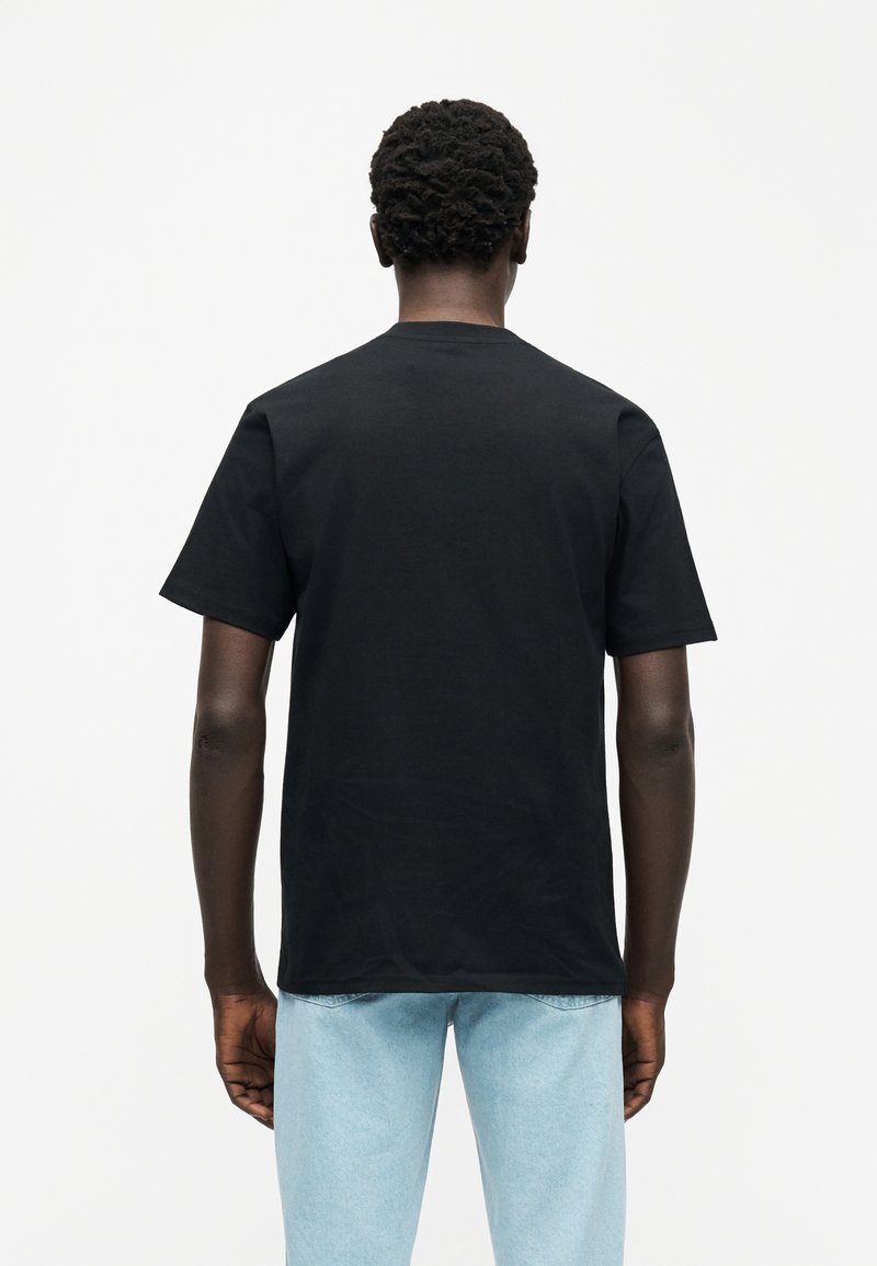 Camiseta negra de algodón con cuello redondo y mangas cortas, dobladillo recto, vista desde atrás sobre un fondo blanco.