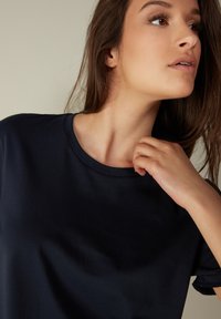 Navyblå t-shirt lavet af blødt stof, med rund halsudskæring, korte ærmer og en afslappet pasform. Glat tekstur med minimale detaljer.