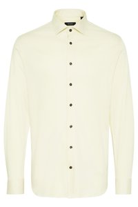 Langarmshirt van lichtgeel stof, met een klassieke kraag en donkerbruine knopen aan de voorkant voor contrast.