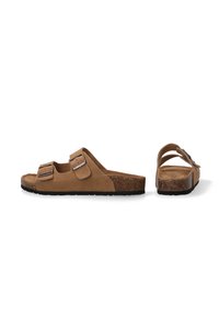 Brown suede slide sandals with two adjustable buckles, cork footbed, and textured black rubber outsole. Minimalist design, open back.