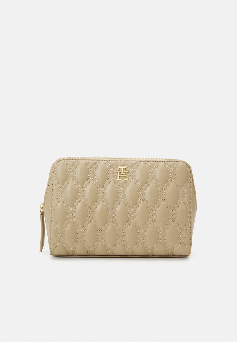 Beige, steppelt kozmetikai táska, arany logóval, cipzárral és texturált mintával. Téglalap alakú, lekerekített élekkel.