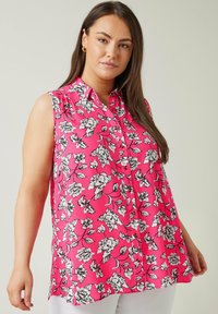 Blusa senza maniche rosa con motivo floreale bianco e nero, design con bottoni frontali, tessuto leggero e vestibilità rilassata.