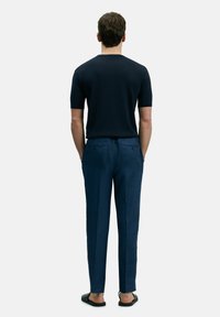 Marineblauwe geribbelde shirt met korte mouwen en een ronde halslijn, gecombineerd met gestructureerde donkerblauwe broeken met achterzakken en een smal model.