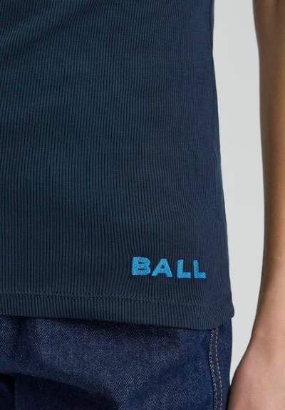 Tricou fără mâneci cu dungi, de culoare bleumarin, având logo-ul brodat "BALL" în culoarea albastră la margine, asociat cu o pereche de blugi negri, evidențiind textura și contrastul de culoare.