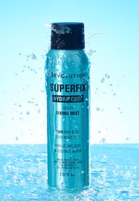 Une bombe de spray de couleur aqua avec un capuchon noir, affichant un texte noir en gras. Contient un spray hydratant avec de l'acide hyaluronique et de l'eau de coco.