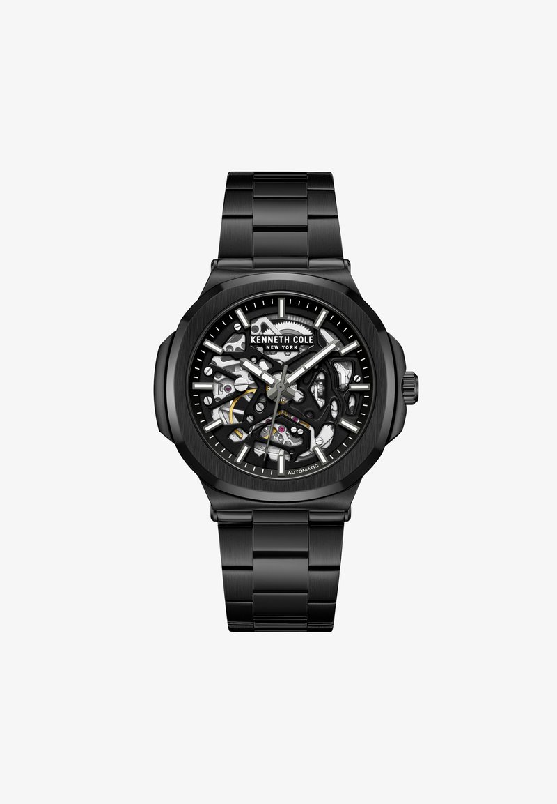 Orologio automatico nero con quadrante skeleton, accenti argentati e bracciale in acciaio inossidabile con finitura lucida. Dettagli di design distintivi visibili.