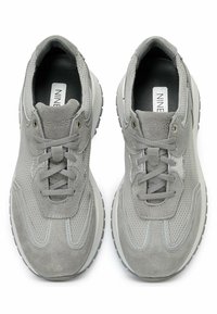 Graue Sneaker aus einer Kombination von Mesh und Wildleder, mit einem abgerundeten Zeh, Schnürsenkeln und einer strukturierten Sohle mit dezenten Akzenten.