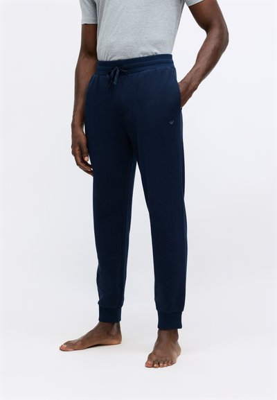 Pantalone jogger mornarice, izrađeni od mekanog materijala, s elastičnim pojasom i vezicom te rebrastim rubovima, dizajnirani za udobnost.