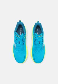 Baskets de sport bleues avec une tige en maille respirante, des accents jaunes et une semelle rembourrée. Dispose de lacets et d'une languette pour un enfilage facile.