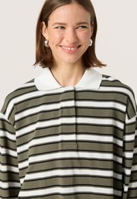 Green and white striped polo shirt with a white collar, made from soft fabric, featuring a button placket and relaxed fit.
