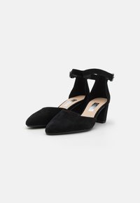 Black suede block-heel pumps with a pointed toe and ankle strap. The strap features a buckle and the insole has a light color.