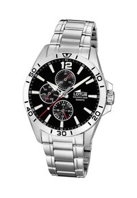 Montre en acier inoxydable argenté avec un cadran noir, présentant des index horaires blancs, des sous-cadrans et des accents rouges. Mouvement à quartz ; affichage 24 heures.
