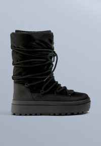 Czarne wodoodporne buty z luźnym fasonem, z miękką tkaniną górną, gumową podeszwą i regulowanymi sznurowadłami zapewniającymi pewne dopasowanie.