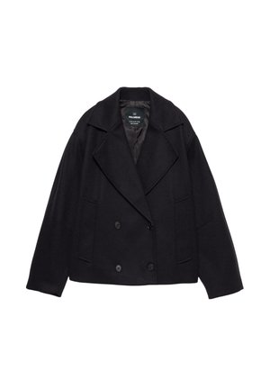 Manteau noir à double boutonnage avec grands revers, manches longues et deux poches avant. Fabriqué en tissu mélangé de laine texturé.