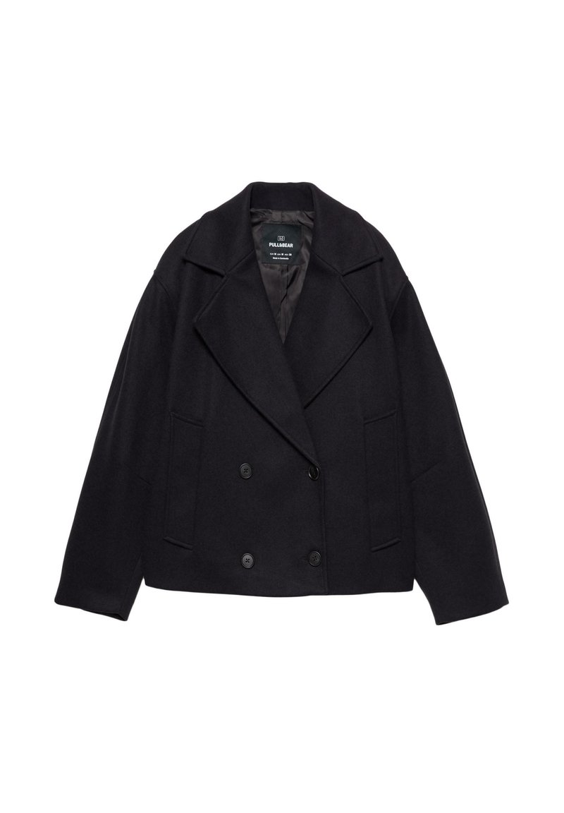 Manteau noir à double boutonnage avec grands revers, manches longues et deux poches avant. Fabriqué en tissu mélangé de laine texturé.