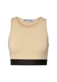 Top bej scurt, dintr-un material neted, cu un band elastic negru în partea de jos, cu branding, și cu un decolteu rotund.