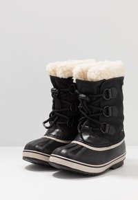 Czarne zimowe buty z sztucznym futrem, gumowymi noskami i tekstylną cholewką. Posiadają regulowane sznurówki i paski na gumowej podeszwie.