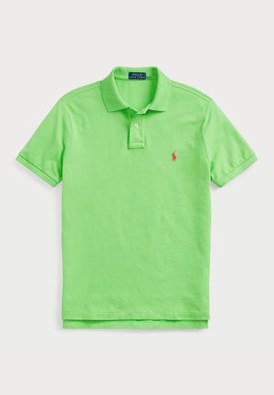 Camisa polo em tecido de algodão verde brilhante. Design clássico com colarinho, mangas curtas e um pequeno logotipo bordado em vermelho no peito.